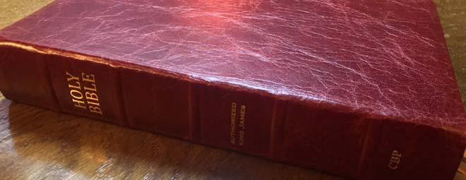Red leather bound bible on a desk